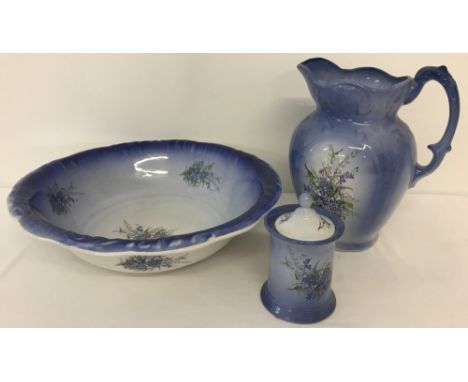 A vintage 3 piece ceramic bathroom set in blue with floral spray decoration. Marked "The Remé collection, Made in England". C