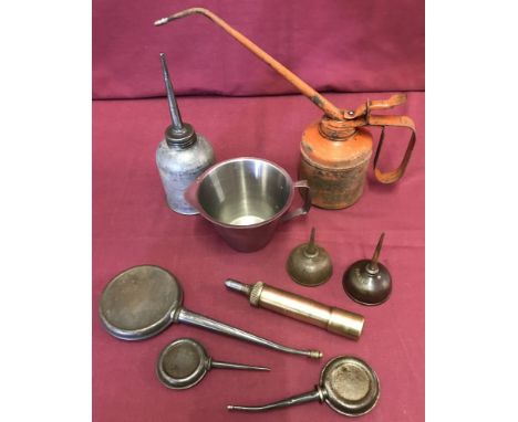 A tray of vintage oils cans. Together with a oil pourer and a motorcycle grease gun.