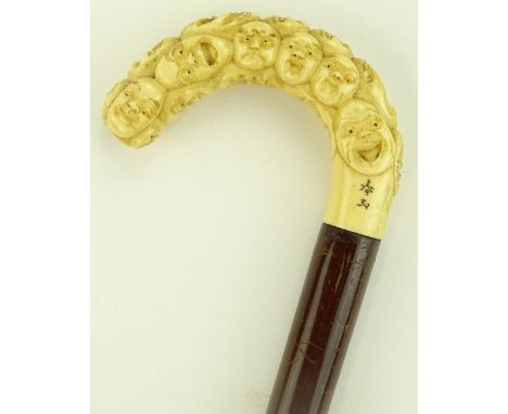 A Japanese Meiji period ivory handled walking stick with carved mask decoration, signed.