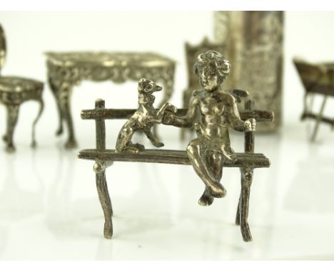 A group of miniature doll's house items, including a cherub on a bench, wheelbarrow, dining table, etc., (6).