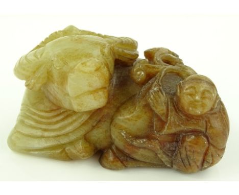 A Chinese russet and white jade carving, buffalo and figure, length 10cm.