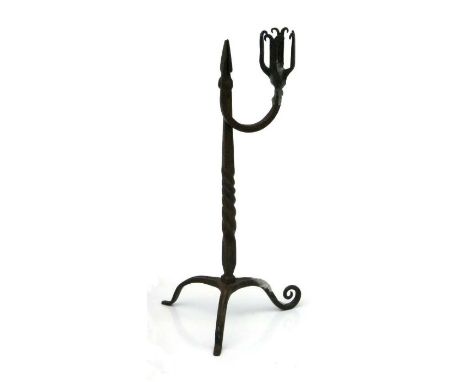 An 18th century style iron rush nip candlestick with barleytwist column on a triform base, 29cms high.