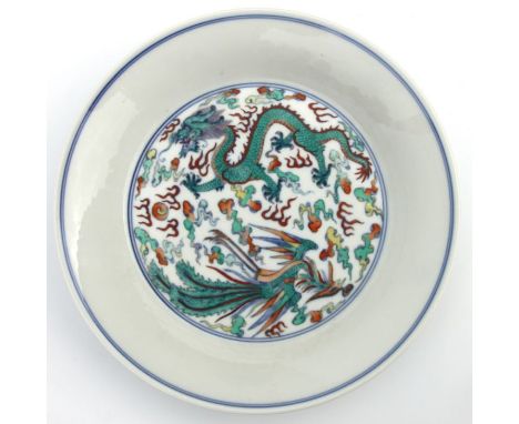 A Chinese Ducai shallow dish decorated with a dragon and phoenix chasing a flaming pearl amongst clouds, blue seal mark to th