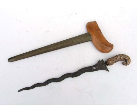 A late 19th or early 20th century Indonesian Kris with wavy pierced blade, intricately carved ivory hilt in its brass and woo