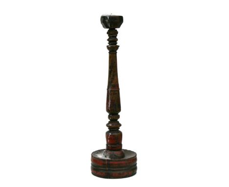 A painted treen candlestick, 49cms high.