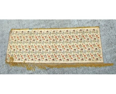 A Kashmiri silk panel decorated with flowers, with fringed edge, 132 by 49cms.
