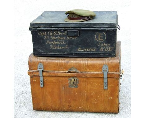 A WWI Officer's peaked cap with Royal Artillery cap badge; together with a black travel trunk, sign written to 'Captain I G G