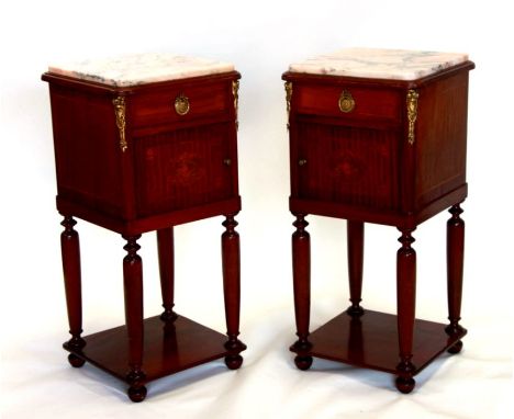 A pair of French mahogany inlaid ormolu mounted pot cupboards, the marble top above a single drawer with cupboard beneath hav