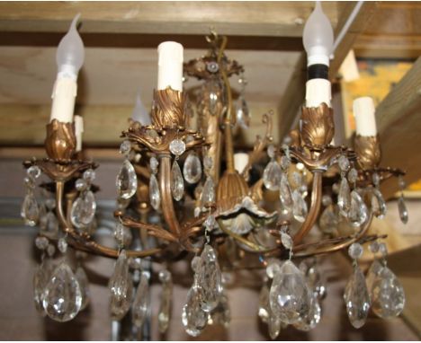 A brass eight-arm electrolier ceiling light with glass drops, 52cms wide.