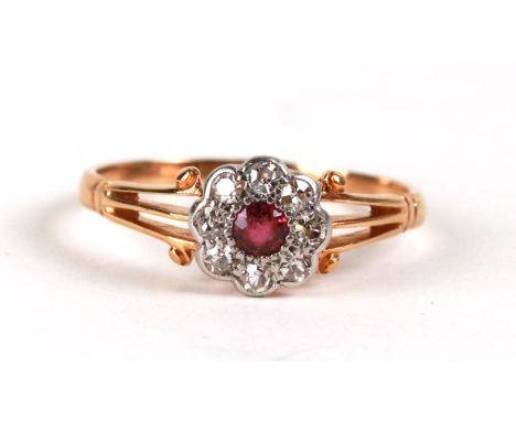 A yellow metal (tests as 18ct) ruby and diamond cluster ring, approx UK size 'Q'.