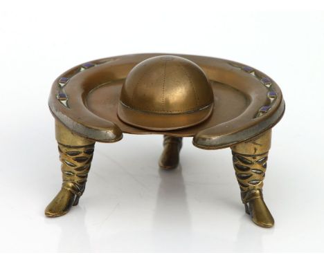 Equestrian interest - a copper, brass and blue enamel horseshoe inkwell with riding boot supports and jockey cap lid (missing