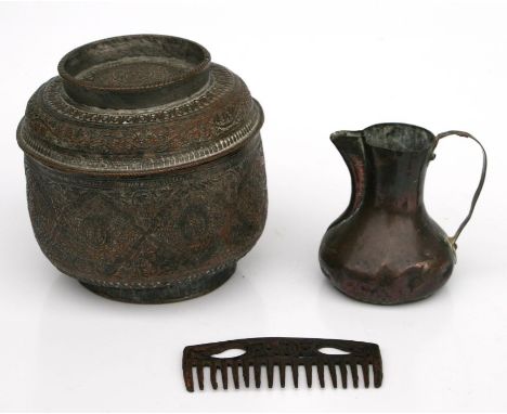 An Indian copper food container with repousse decoration, 16cms diameter; together with a copper jug and iron comb (3).