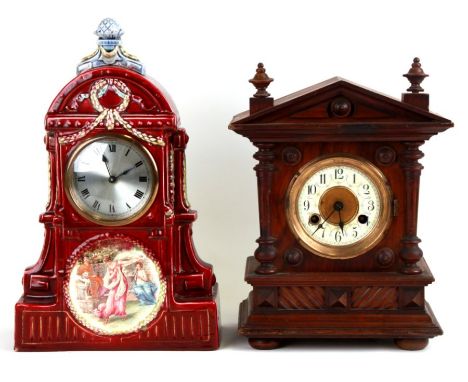 A mantle clock, the silvered dial with Roman numerals, in a ceramic case decorated with a classical scene, 24cms wide. togeth