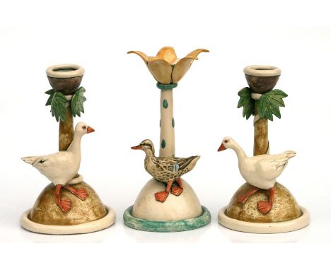  A pair of pottery candlesticks with applied geese by Anna Lambert, 20cms high; together with another similar applied with a 