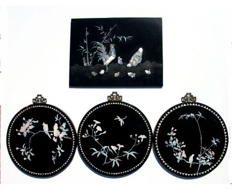A set of three Chinese lacquer circular wall hanging plaques with mother of pearl inlay depicting birds, insects and foliage,