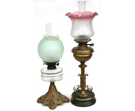 A Victorian oil lamp with brass reservoir and column and etched glass shade, 60cms high; together with another similar with o