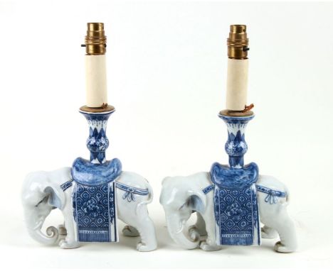 A pair of Chinese blue &amp; white candlesticks in the form of elephants, converted to table lamps, 22cms high, 34cms high in