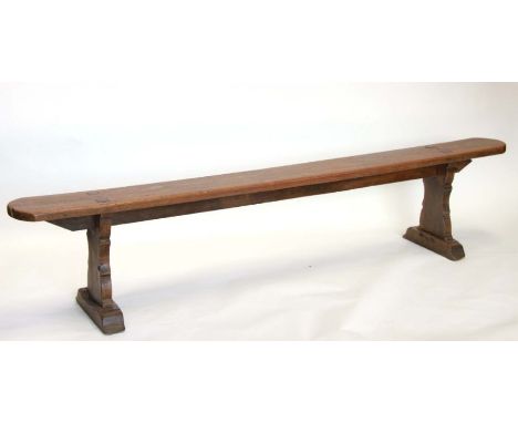A large elm bench of slender proportions with rounded rectangular top on shaped end supports, 218cms long.