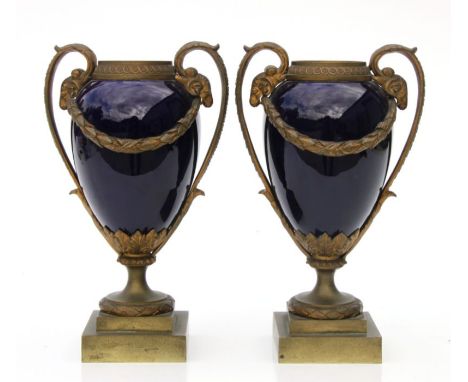 A pair of late 19th century Adam style ormolu mounted enamel urns with rams head scroll handles, 18cms high (2).