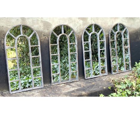 ARCHITECTURAL GARDEN MIRRORS, 60cm high, 32cm wide, a set of four, Regency style, arched metal frames, aged finish. (4) 