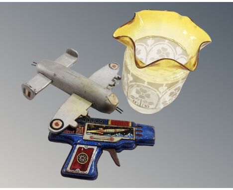 A vintage two-tone glass oil lamp shade together with a model aeroplane and tin plate rocket gun 