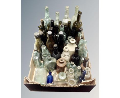 A box containing antique glass and ceramic bottles including brewery and chemist examples.
