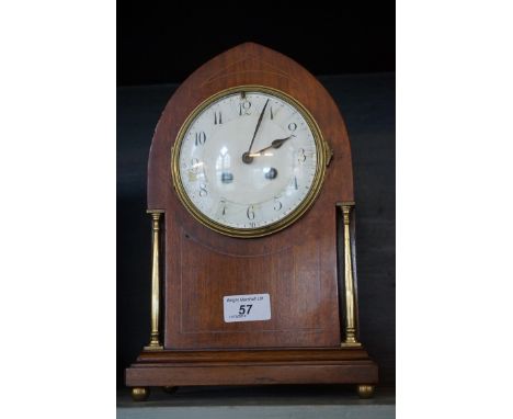 An Edwardian inlaid mahogany arched topped bracket clock raised on gilt brass feet.