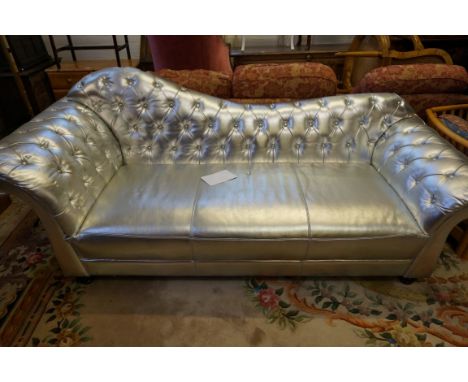 A contemporary silvered couch with an arched padded back over button back scroll arms , raised on vase shaped feet.