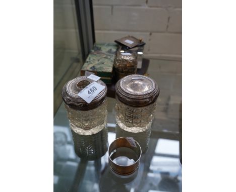 A mixed group of hallmarked silver items to include two cut glass and hallmarked silver topped dressing table jars, napkin ri