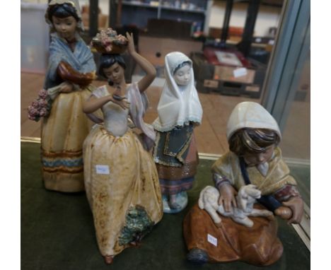 A group of four Lladro figurines to include three matt examples and an example of a lady in a shawl. (4)