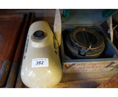 A vintage miliatry compass inset in wooden case together with a stoneware hot bottle.