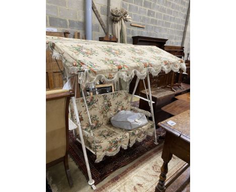 A vintage metal garden swing seat with printed floral covers, width 170cm, depth 104cm, height 180cm