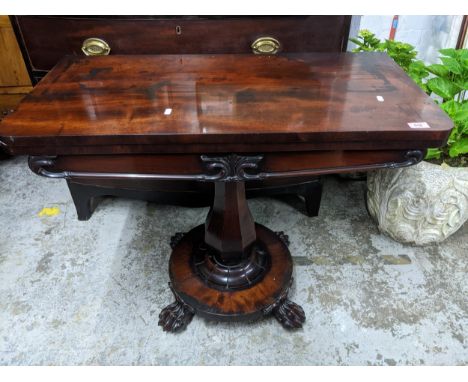 A Regency mahogany folding swivel top card table, the top with circular inset baize, on fluted baluster column and circular b