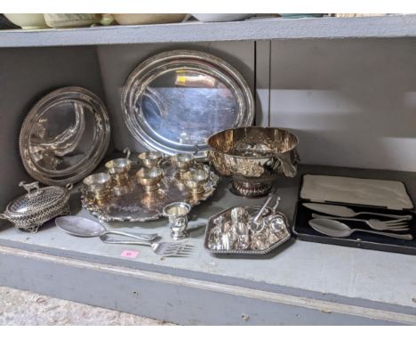 A selection of silver plated items to include a punch bowl and cups with ladle, circular Sheffield plated tray with cast feet