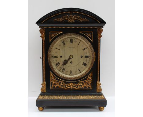 An early 20th century ebonised bracket clock, the domed top with gilt metal beading and leaf decoration with leaf cast column
