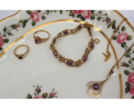 A 9ct yellow gold and amethyst set bracelet with oval links, together with two amethyst and yellow metal rings and an amethys