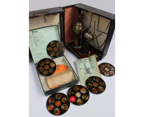 An Ernst plank magic lantern with a brass globe body on a cylindrical foot, contained in a leatherette box and slides CONDITI