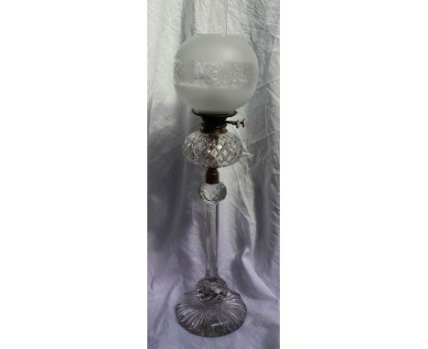A Victorian glass oil lamp the later etched glass globe shade above a cut glass reservoir, the column with faceted ball decor
