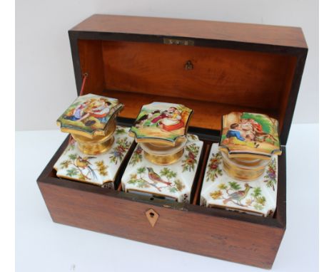 A Victorian rosewood tea caddy of rectangular form with a central ring handle, the interior fitted with three porcelain lidde