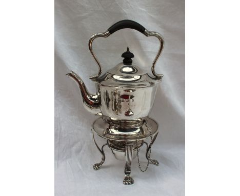 A George V silver kettle on stand with a shaped handle and a tapering body, the base with four legs and lions paw feet and a 