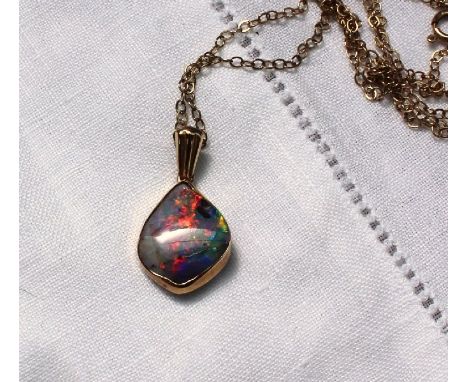 A fire opal mounted in 9ct yellow gold pendant on a 9ct yellow gold chain CONDITION REPORT: Pendant approximately 14mm x 11mm
