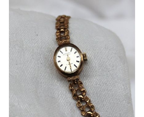 A 9ct yellow gold lady's Rotary wristwatch, together with a yellow metal bar brooch, compact and 1881 dollar