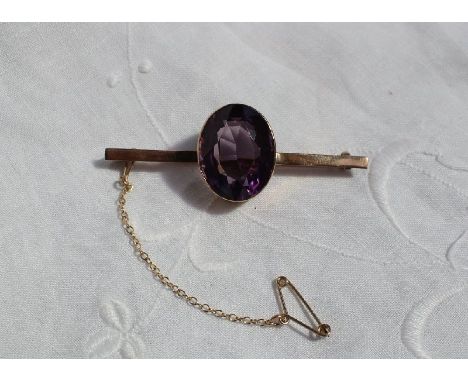 A 9ct yellow gold bar brooch set with a large oval faceted amethyst