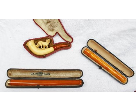 A yellow metal mounted amber cheroot holder (cased) together with a meerschaum pipe in the form of a standing wolf, costume j