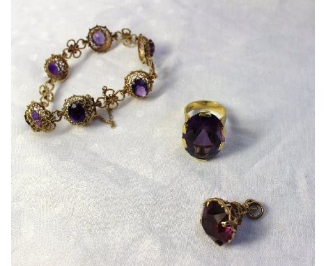 An amethyst dress ring, the large oval faceted stone to a yellow metal setting and textured shank marked 18ct, together with 