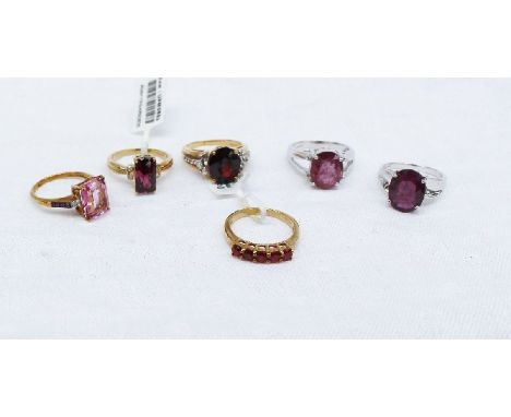 A 9ct yellow gold ruby line ring together with a garnet and topaz ring and a collection of 9ct yellow gold dress rings