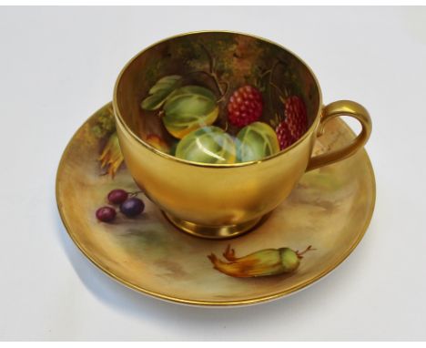 A Royal Worcester porcelain cabinet tea cup and saucer painted with gooseberries, raspberries apples and hazelnuts to a natur