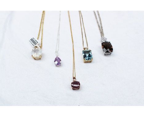 A ruby and diamond pendant together with four other semi precious set pendants