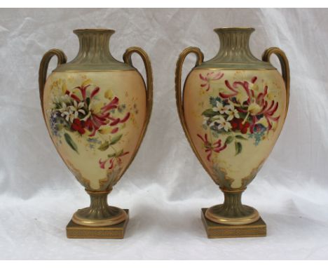 A pair of Royal Worcester porcelain twin handled vases painted with honeysuckle and other garden flowers to an ivory ground o