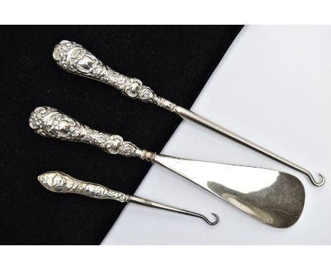 TWO SILVER HANDLED BUTTON HOOKS AND A SILVER HANDLED SHOE HORN, a button hook and shoe horn silver handled set, detailed with